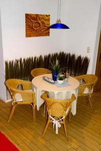 a table with wicker chairs and a table with a plant on it at Ferienwohnung Falk in WÃ¶lpinghausen