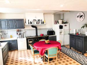una cocina con una mesa con un mantel rojo. en La Maison du Bonheur maison de campagne 20 personnes avec jacuzzi, en Anneyron