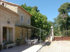 Casa de piedra con patio con mesa y sillas en Ancien Mas viticole à 10 min de Narbonne, en Bizanet