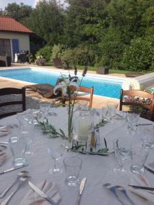 a table with glasses and a vase of flowers on it at Logis Hotel La Grange Du Relais in Colombey-les-deux-Églises
