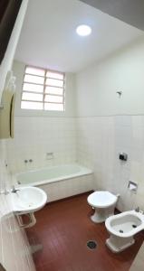 a bathroom with two toilets and a bath tub at Hotel Sao Nicolau in Taubaté +69 photos
