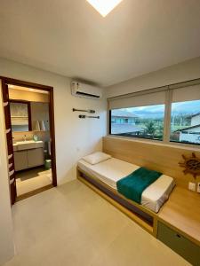 ein Schlafzimmer mit einem Bett und einem großen Fenster in der Unterkunft Casa Luxo com piscina privativa próximo a Igrejinha - Com colaboradora e enxoval in Praia dos Carneiros