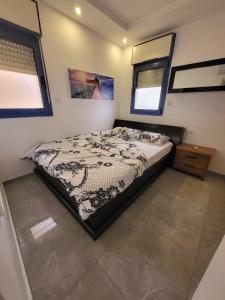 a bedroom with a bed and two windows at רויאל פארק אילת in Eilat