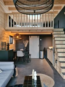 un soggiorno con un divano e un tavolo di Nieuw! Sfeervol Tiny House in de natuur en aan het water a Hulshorst
