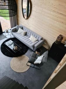 a living room with a couch and a table at Nieuw! Sfeervol Tiny House in de natuur en aan het water in Hulshorst