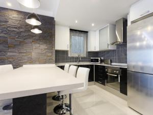 uma cozinha com uma mesa branca e uma parede de pedra em Beautiful apartment in the center equipped for 7 em Barcelona