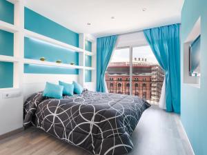 um quarto com uma cama com paredes azuis e uma janela em Beautiful apartment in the center equipped for 7 em Barcelona