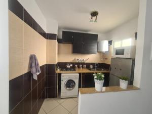 a kitchen with a washing machine and a washer at NRY Home magnifique Appartement , prêt de plage in Martil