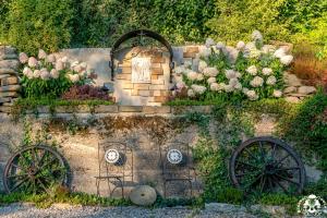 a garden with two wagon wheels and flowers at Agroturystyka Corno Owca in Żabnica