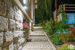 a stone walkway next to a stone wall at Agroturystyka Corno Owca in Żabnica