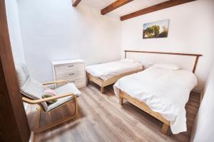 1 dormitorio con 2 camas, silla y cómoda en Finca Ecológica Ferrera. Alojamiento Rural., en Arafo