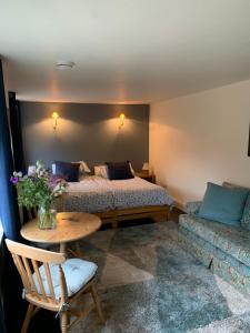 BanhamにあるBluebell Barnのベッド2台、テーブル、ソファが備わる客室です。