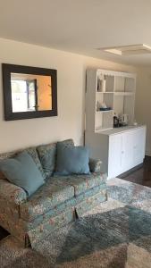 a living room with a couch and a mirror at Bluebell Barn in Banham