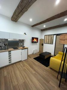 sala de estar con cocina y sofá amarillo en Loft atypique sétois, en Sète