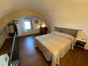 - une chambre avec un lit dans une pièce avec une arche dans l'établissement La casa dei ricordi, à San Gimignano