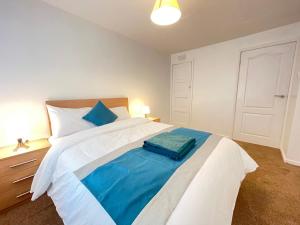 a bedroom with a large bed with a blue blanket at Durham Eastside Professional Let - Durham city in Ushaw Moor