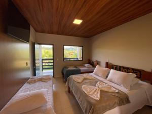 a bedroom with two beds and a window at Tijota Hotel Fazenda in Ipatinga