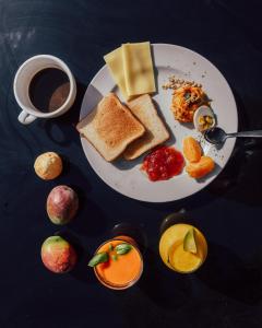 a plate of breakfast foods and a cup of coffee at Los Amigos Hostel Tenerife in La Mareta