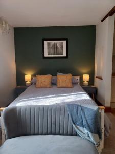 a bedroom with a bed with a green wall at Stowe Fields in Northampton