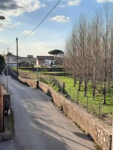 una strada vuota con un muro di contenimento e alberi di La Sosta a Sant'Egidio del Monte Albino