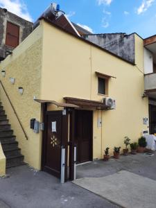 un edificio giallo con una porta e una scala di La Sosta a Sant'Egidio del Monte Albino