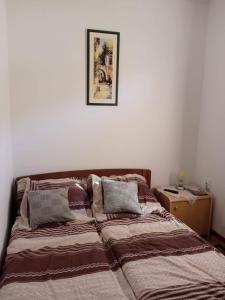 a bed in a bedroom with a picture on the wall at Kuća Talija in Kalna