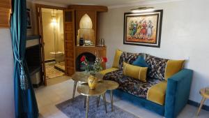uma sala de estar com um sofá e uma mesa em Riad Samsli em Marraquexe