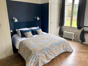 una camera da letto con un grande letto con pareti blu di Domaine de la Cressonnière 