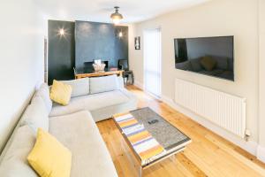 a living room with a couch and a tv at The Railway Inn - 3 Bed Luxury Stay in Milton Keynes