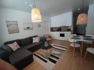 ein Wohnzimmer mit einem Sofa und einem Tisch in der Unterkunft Kanervikko in Kalajoki
