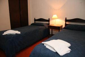 2 Betten in einem Hotelzimmer mit Handtüchern darauf in der Unterkunft Hotel Yaro in Gualeguaychú