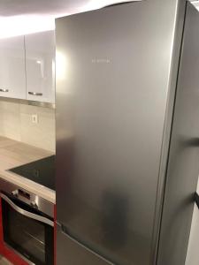einen Kühlschrank aus Edelstahl in der Küche in der Unterkunft Μία γκαρσονιέρα με γούστο για επισκέπτες με άποψη in Athen