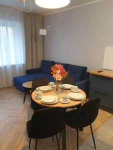 sala de estar con mesa con sillas y sofá azul en Modern Apartment, en Opole