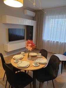 a dining room with a table with chairs and a television at Modern Apartment in Opole