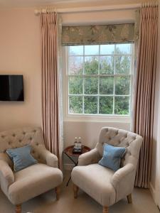 a living room with two chairs and a window at The Seagrave Arms in Weston Subedge