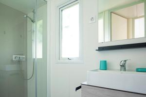 a bathroom with a shower and a sink and a mirror at Mobile Home OuiReves 513 facing the Mediterranean in Lattes