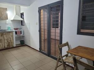 a kitchen with a table and a wooden door at Depto Céntrico II in Corrientes