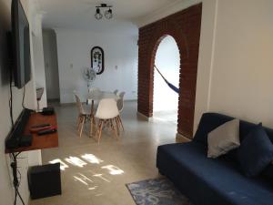 a living room with a couch and a table with chairs at Pequeño Paraíso un lugar ventilado y acogedor in El Placer