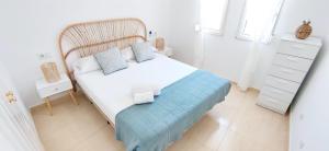 een slaapkamer met een wit bed met een houten hoofdeinde bij Apartamento El Sueño II in Denia