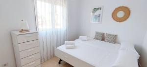 een witte slaapkamer met een wit bed en een dressoir bij Apartamento El Sueño II in Denia