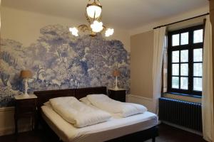 um quarto com uma cama com papel de parede azul e branco em Het Domherenhuis em Heusden - Zolder