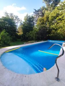 una piscina azul con una escultura de metal en el medio en Casa Cuatro Robles en Mar del Plata