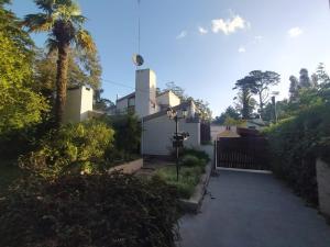 una entrada que conduce a una casa con una valla en Casa Cuatro Robles en Mar del Plata