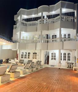 duży biały budynek z krzesłami i stołami w nocy w obiekcie Casa Dimares w mieście Cartagena de Indias