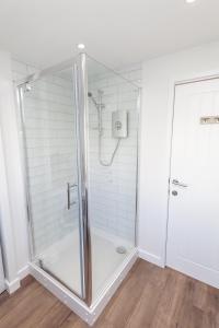 a shower with a glass door in a bathroom at Dartside 55 in Dartmouth