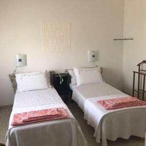 two beds in a room with white walls at Casa Giulia in Porto SantʼElpidio