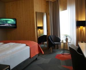 a hotel room with a television and a bed at Landhotel in Hella