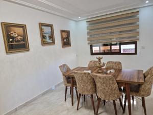 a dining room with a wooden table and chairs at Nice appartment nador al jadid in Nador