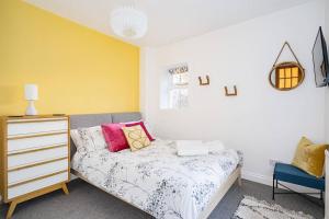 a bedroom with a bed and a dresser and a yellow wall at BRAND NEW LSITING!Wonderful One Bedroom Apartment in Bath