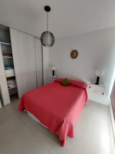- une chambre avec un lit rouge et une couverture rouge dans l'établissement AQUAMARINA 2, à Puerto Madryn